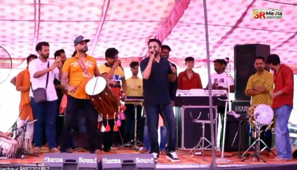 Singer hurts religious sentiments – गायक माशा अली ने उड़ाया धर्म का मजाक, लखदाता दरबार में लगे मेलें में स्टेज पर बूट पहन कर पेश किया कार्यक्रम